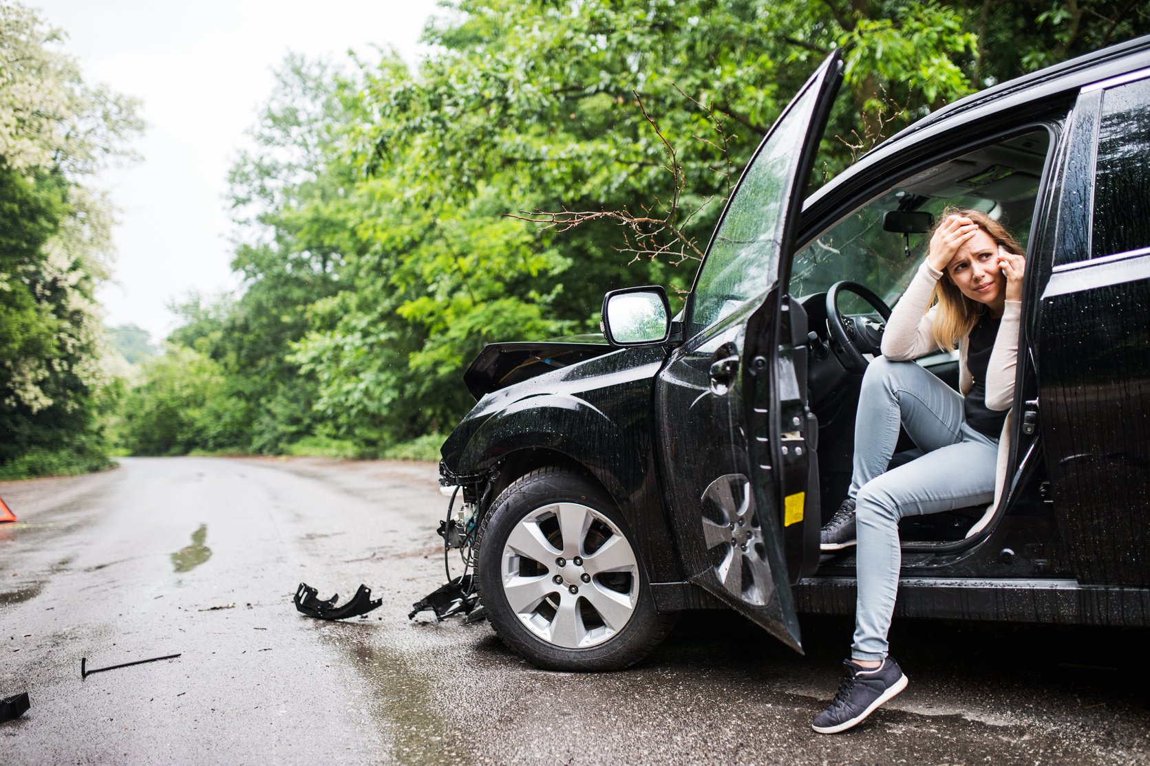 Young Woman in the Damaged Car after a Car Accident, Making a Phone Call.